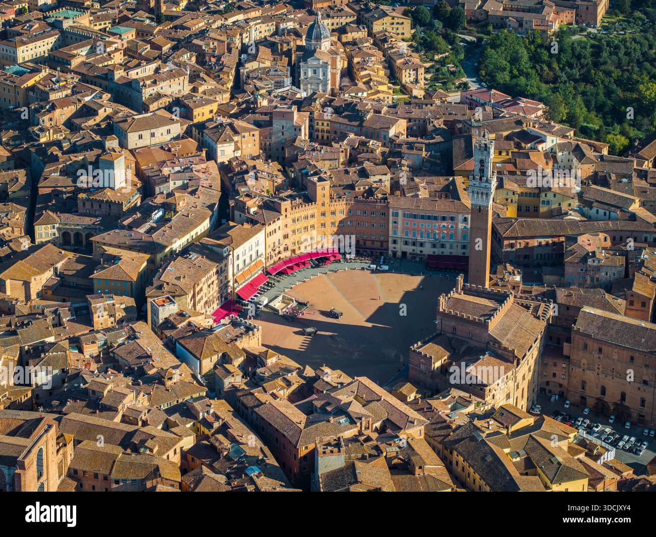 Vue aérienne de Piazza del Campo et Torre del Mangia baignées de soleil, projetant de longues ombres sur les toits antiques, Sienne, Toscane, Italie. Banque D'Images