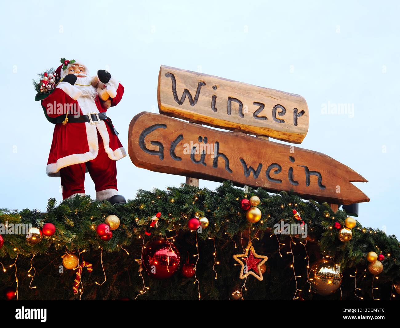 Panneau en bois lisant 'Winzer Gluhwein' avec la figure du Père Noël et les décorations de sapin de Noël Banque D'Images
