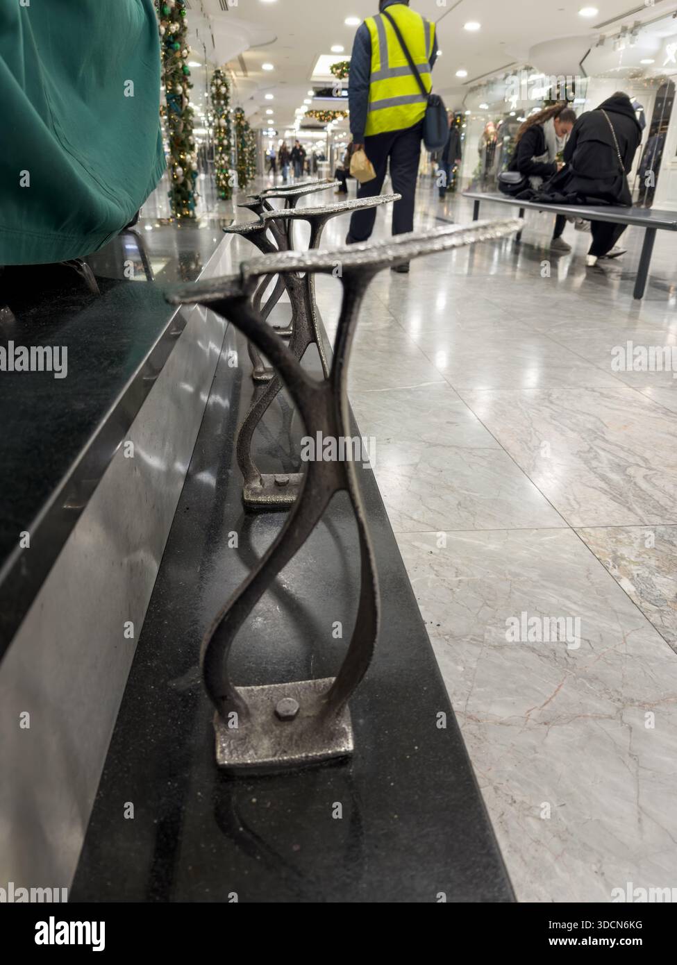 Repose-pieds traditionnel pour cireuse de chaussures au centre commercial Canary Wharf, Londres, avec décorations de Noël et clients en arrière-plan. Banque D'Images