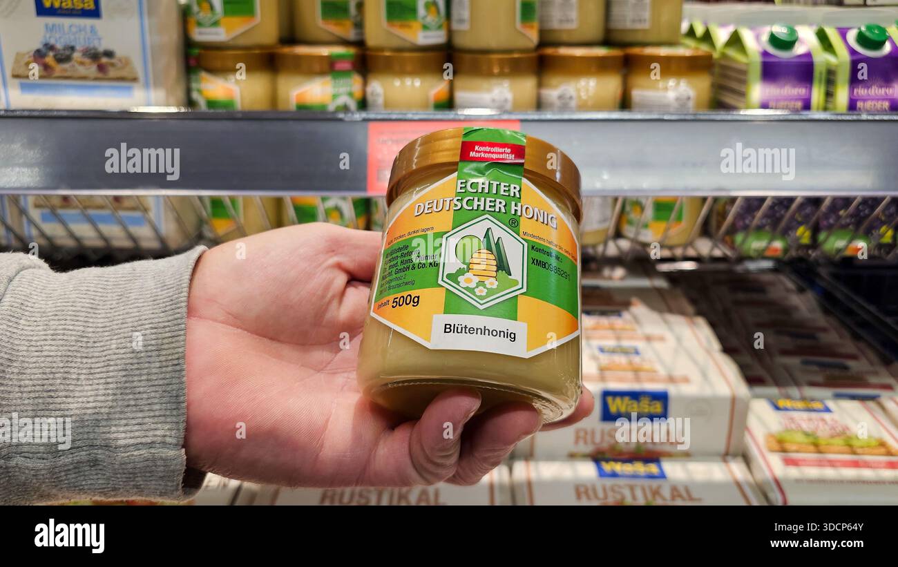 Menden, NRW, Allemagne – 29 juillet 2025 miel d'Allemagne : verre de miel de fleur à la main Banque D'Images