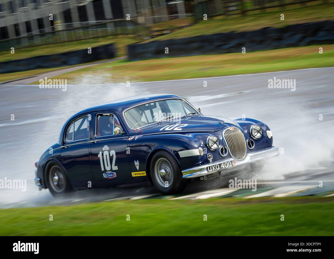 Voiture de course Jaguar 3,4 litres Mark I Black Beroon 1957 sous la pluie au Goodwood Revival 2025 Banque D'Images
