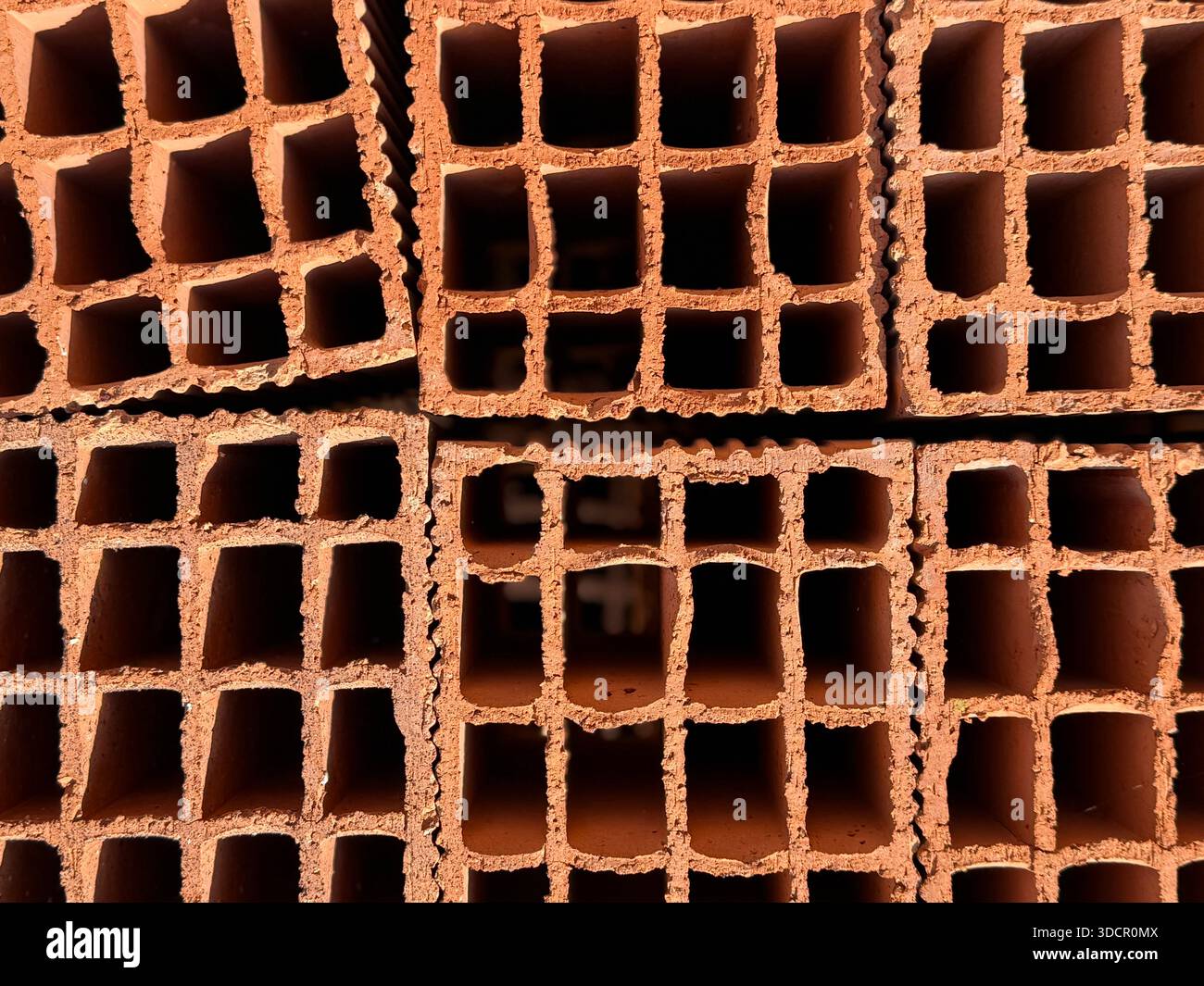 Fond de mur de briques présentant plusieurs briques creuses empilées avec des ouvertures en forme de grille. Photo mobile Banque D'Images