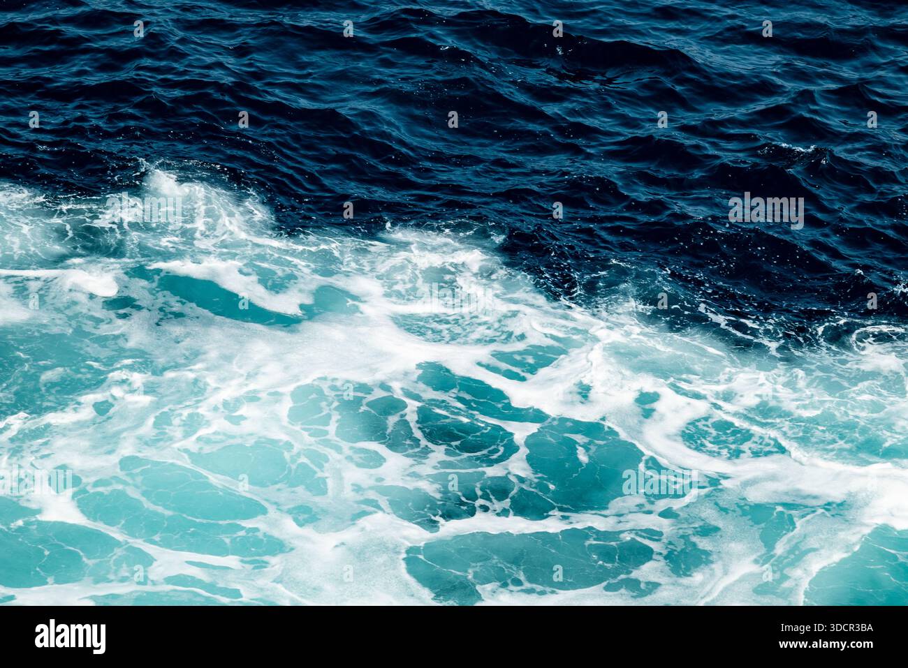 Vagues qui s'écrasent dans l'océan avec différentes nuances de bleu. Banque D'Images