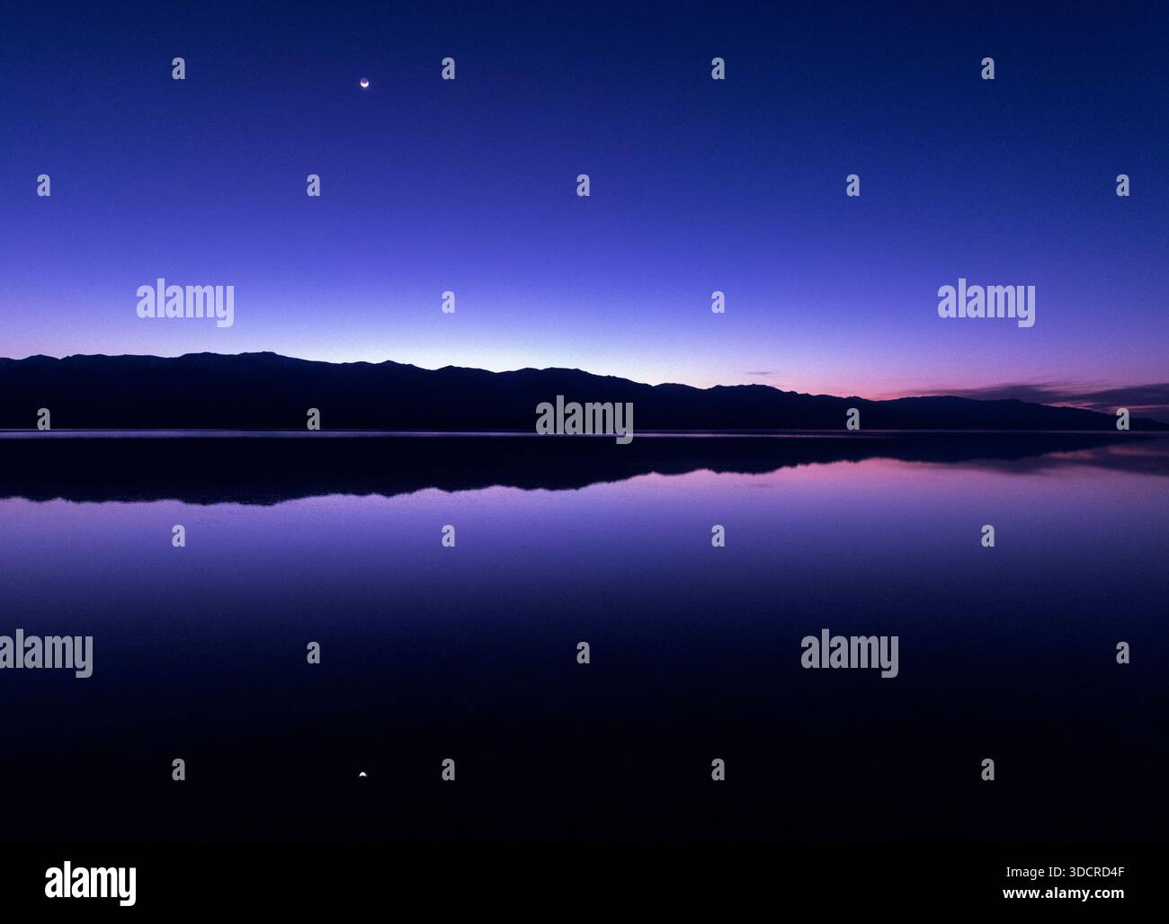Croissant de lune au-dessus des Panamints et du lac Manly, dans le parc national de la Vallée de la mort, Californie Banque D'Images