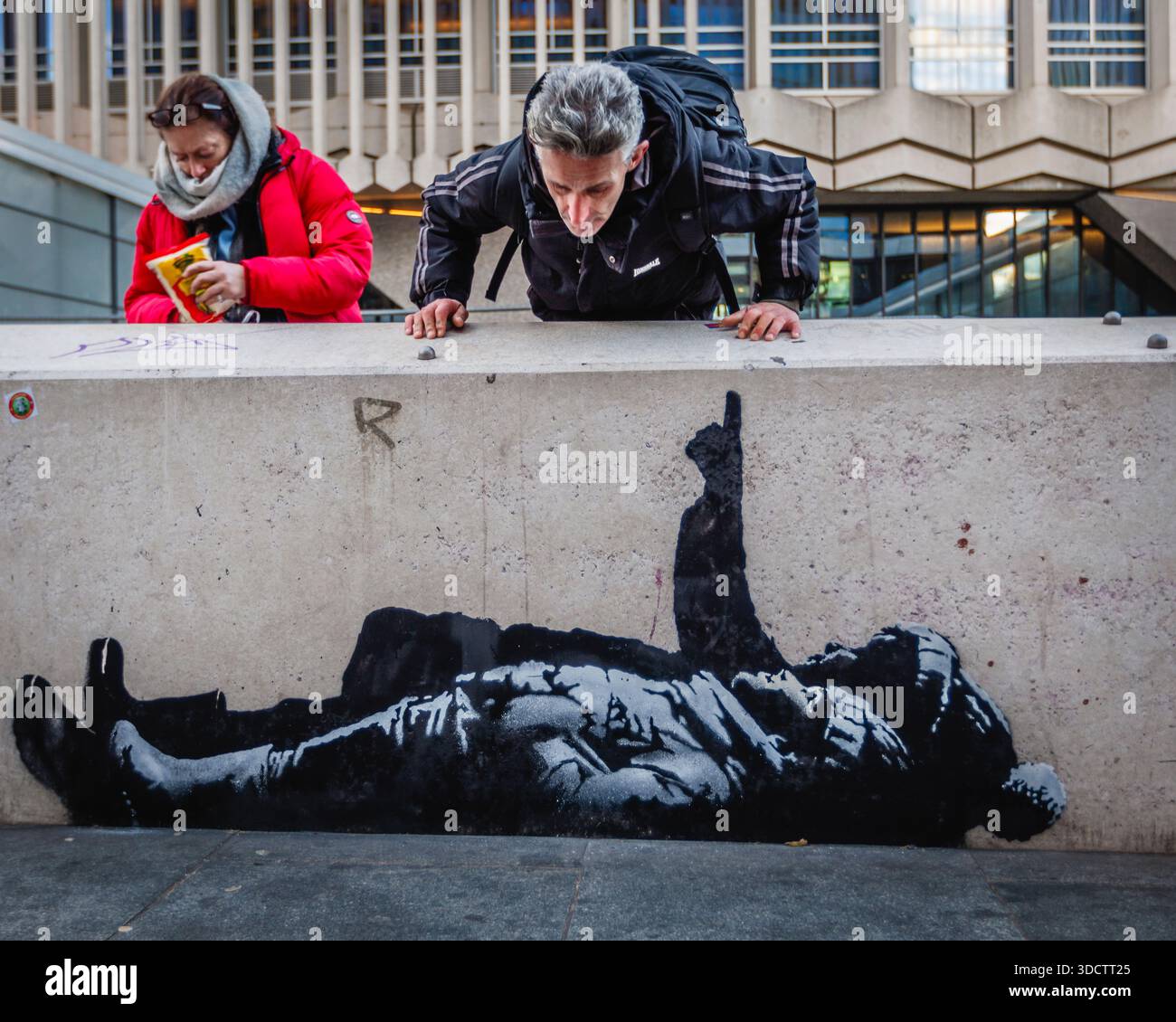 Les passants s'arrêtent pour admirer le dernier art Banksy de deux enfants sans abri pointant vers le ciel à l'extérieur de Centre point à Londres. Banque D'Images