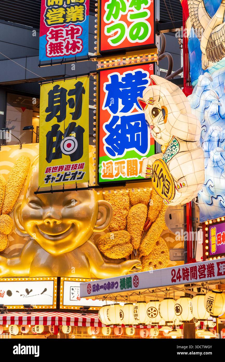 Plan en perspective compressé formant un kaléidoscope de diverses icônes en relief illuminées au-dessus des restaurants japonais. Tortue, chat chanceux et Billiken. Banque D'Images