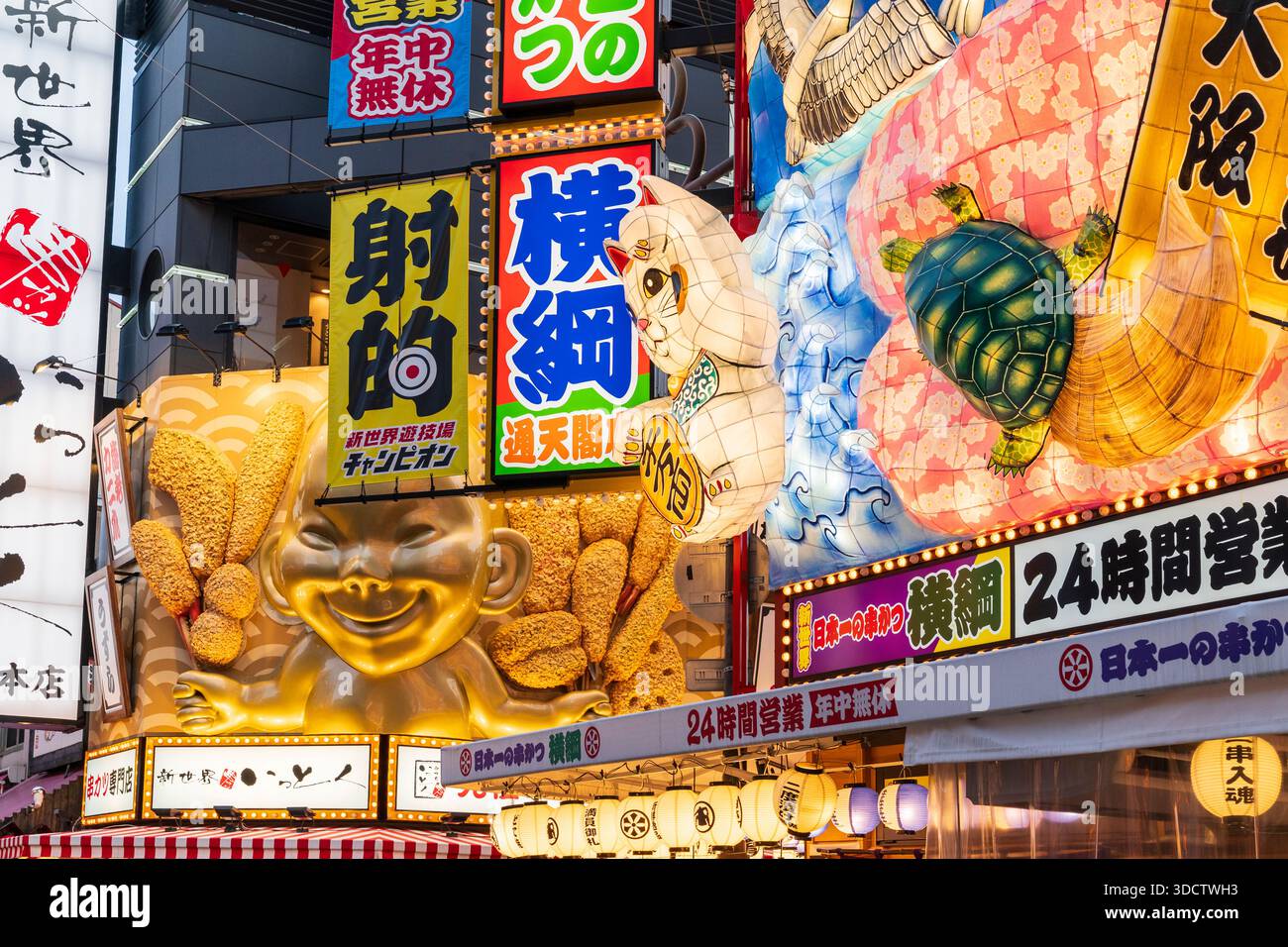 Plan en perspective compressé formant un kaléidoscope de diverses icônes en relief illuminées au-dessus des restaurants japonais. Tortue, chat chanceux et Billiken. Banque D'Images