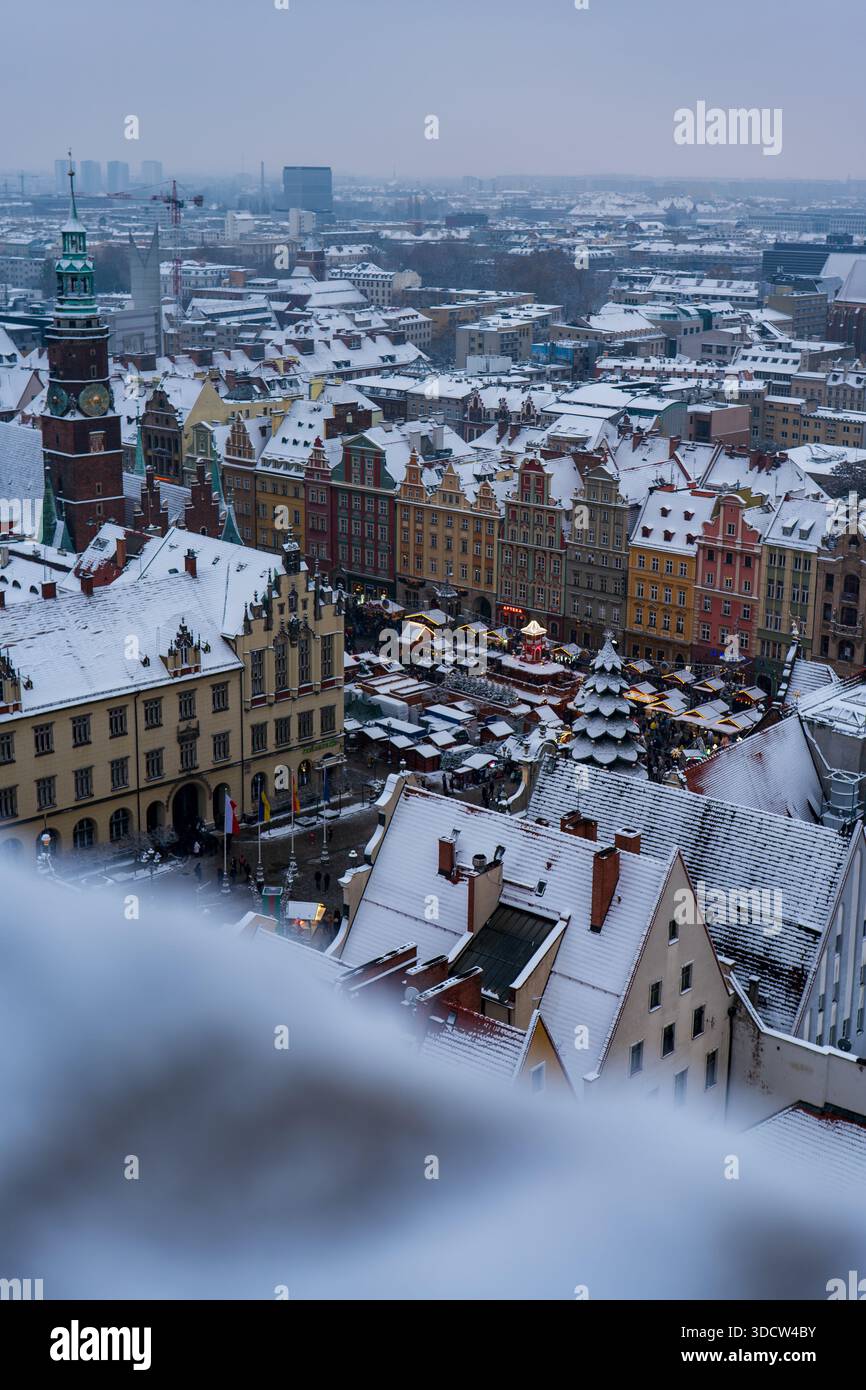 Vue aérienne de Wroclaw Rynek avec façades pastel, vieil hôtel de ville gothique, tour de l'horloge d'Elizabeth, stalles de chalet, et une pyramide de Noël incandescente Banque D'Images