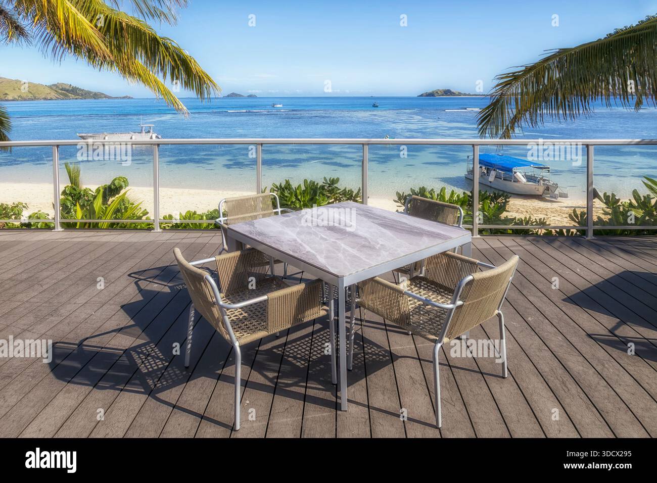 Table à manger et chaises sur une terrasse en bord de mer à Tropical Beach dans les îles Fidji pacifique. Banque D'Images