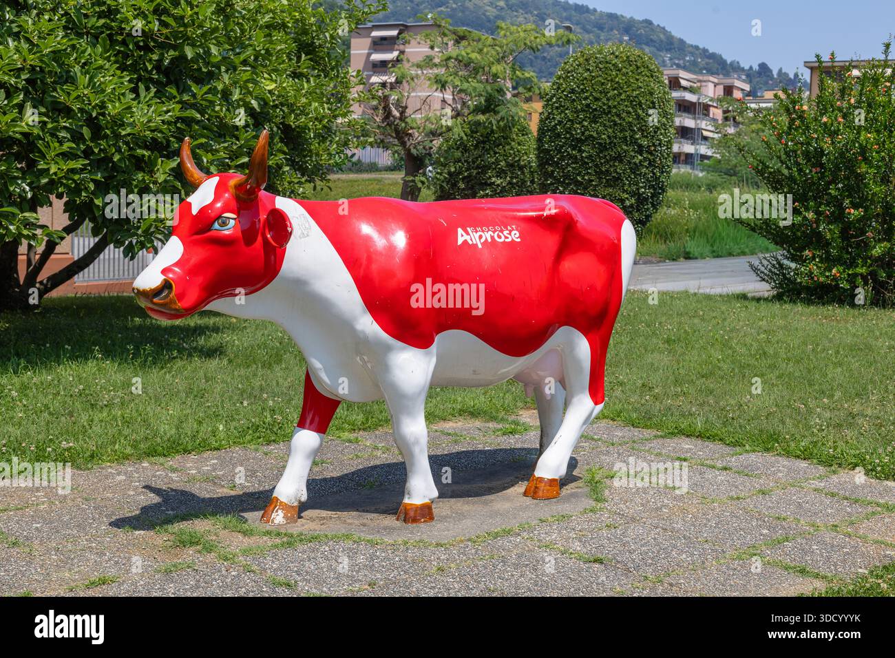 CASLANO, SUISSE, 06.20.2025 :Une statue de vache rouge et blanche brillamment peinte. Exposition interactive et tout sur l'histoire du chocolat ma Banque D'Images