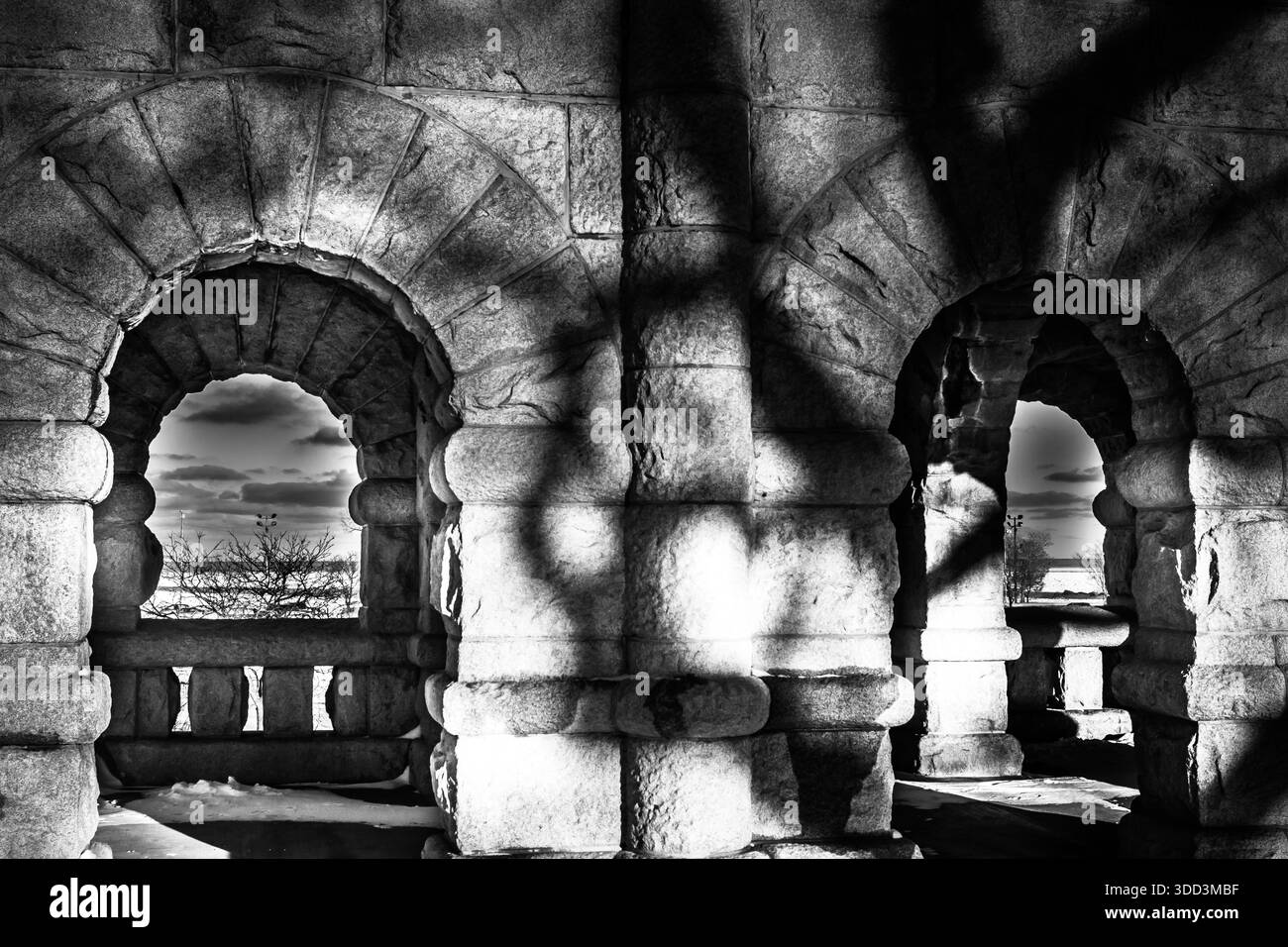 Vue monochromatique à travers les arches massives en pierre rustiquée de l'arcade du monument Ulysses S. Grant à Lincoln Park, Chicago. Banque D'Images