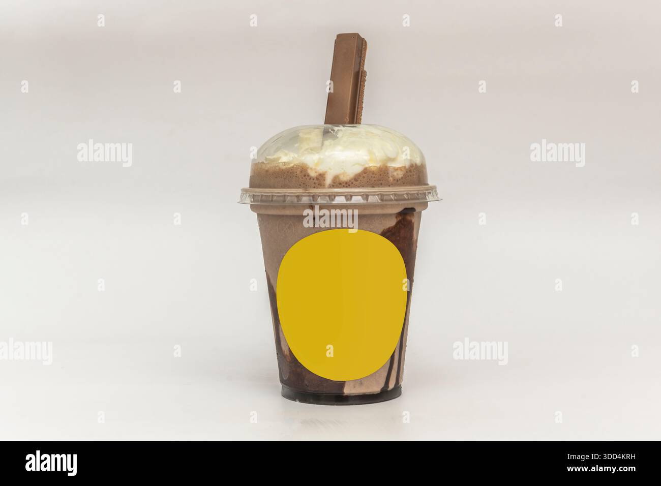 Un milkshake avec un biscuit au chocolat dans une tasse en plastique pour la livraison à domicile Banque D'Images