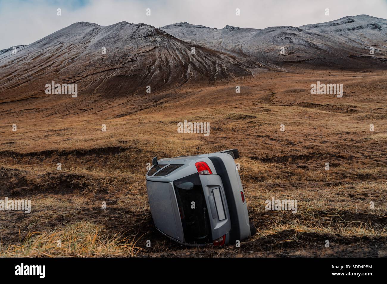 Voiture renversée par le vent. Petite voiture cassée au milieu d'une vallée désertique. Accident de la route, personne, précautions, longs trajets dans les régions reculées. Banque D'Images