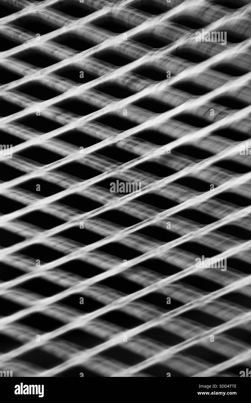 image de fond verticale abstraite de la grille métallique avec des formes de diamant prises avec une exposition de longue durée et un mouvement intentionnel de la caméra pour représenter le mouvement Banque D'Images