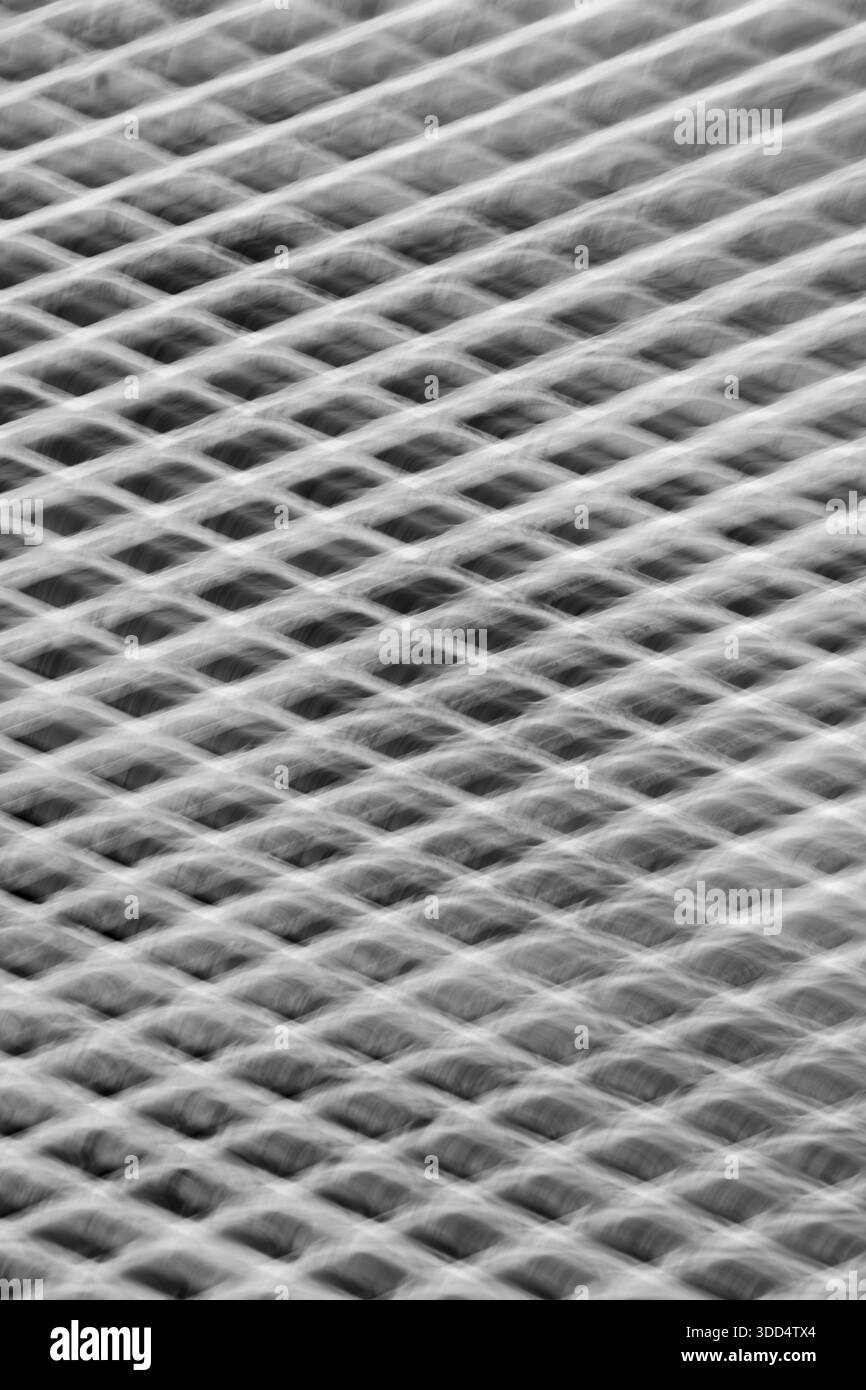 image de fond verticale abstraite de la grille métallique avec des formes de diamant prises avec une exposition de longue durée et un mouvement intentionnel de la caméra pour représenter le mouvement Banque D'Images