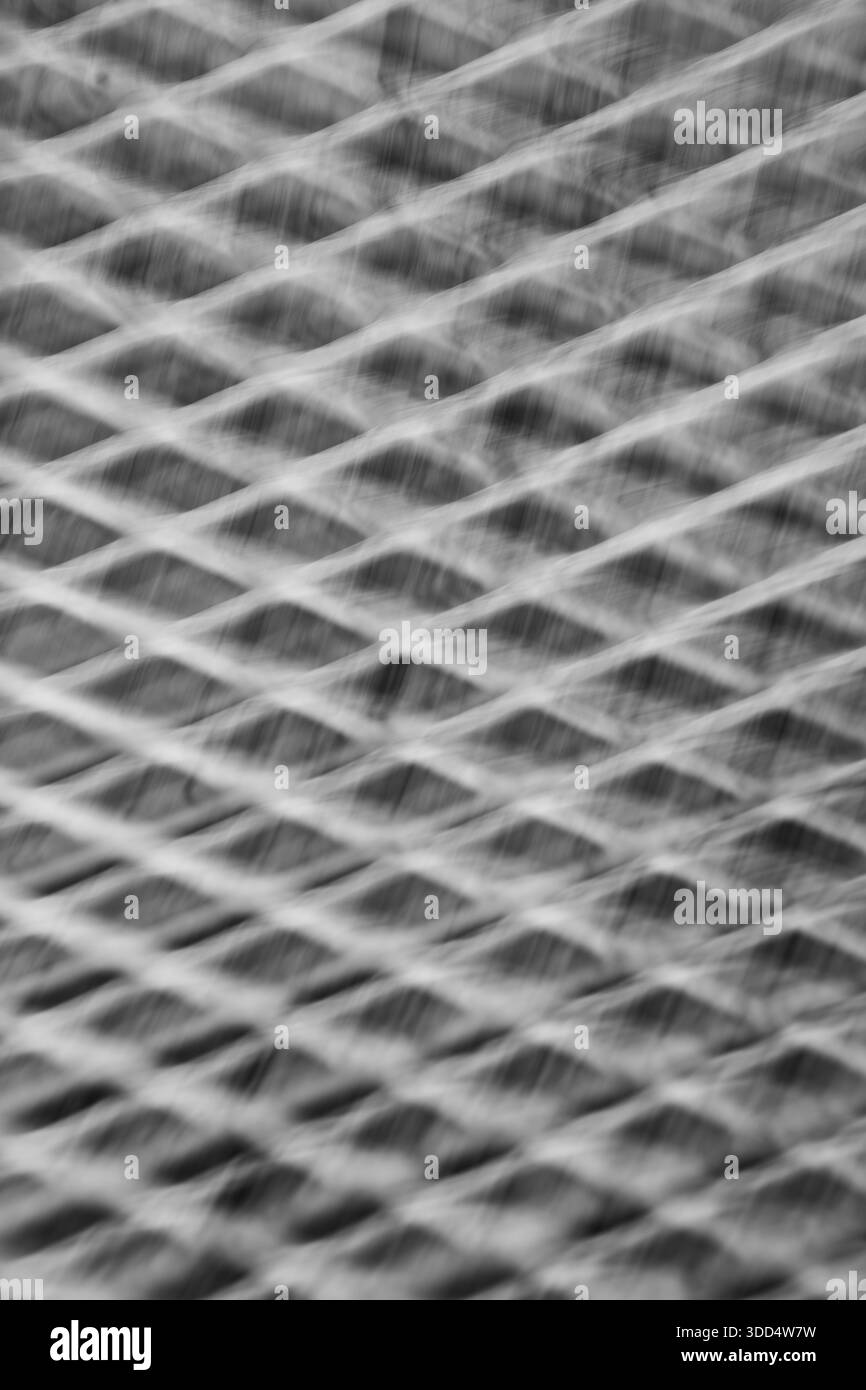 image de fond verticale abstraite de la grille métallique avec des formes de diamant prises avec une exposition de longue durée et un mouvement intentionnel de la caméra pour représenter le mouvement Banque D'Images