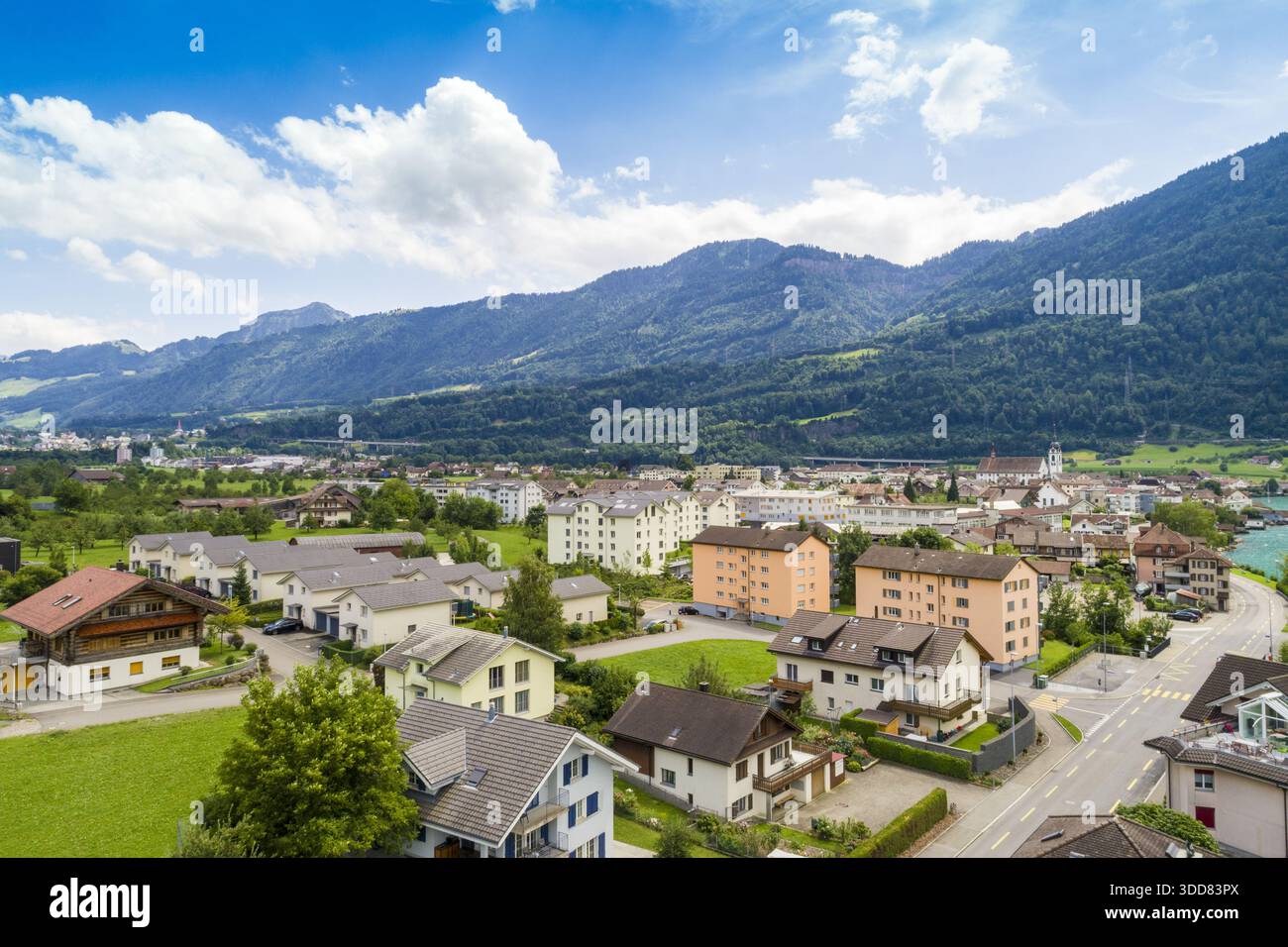 Vue aérienne de maisons et de bâtiments nichés dans une vallée sous d'imposantes montagnes, un contraste vibrant de paysages urbains et naturels, Treptower Park Banque D'Images