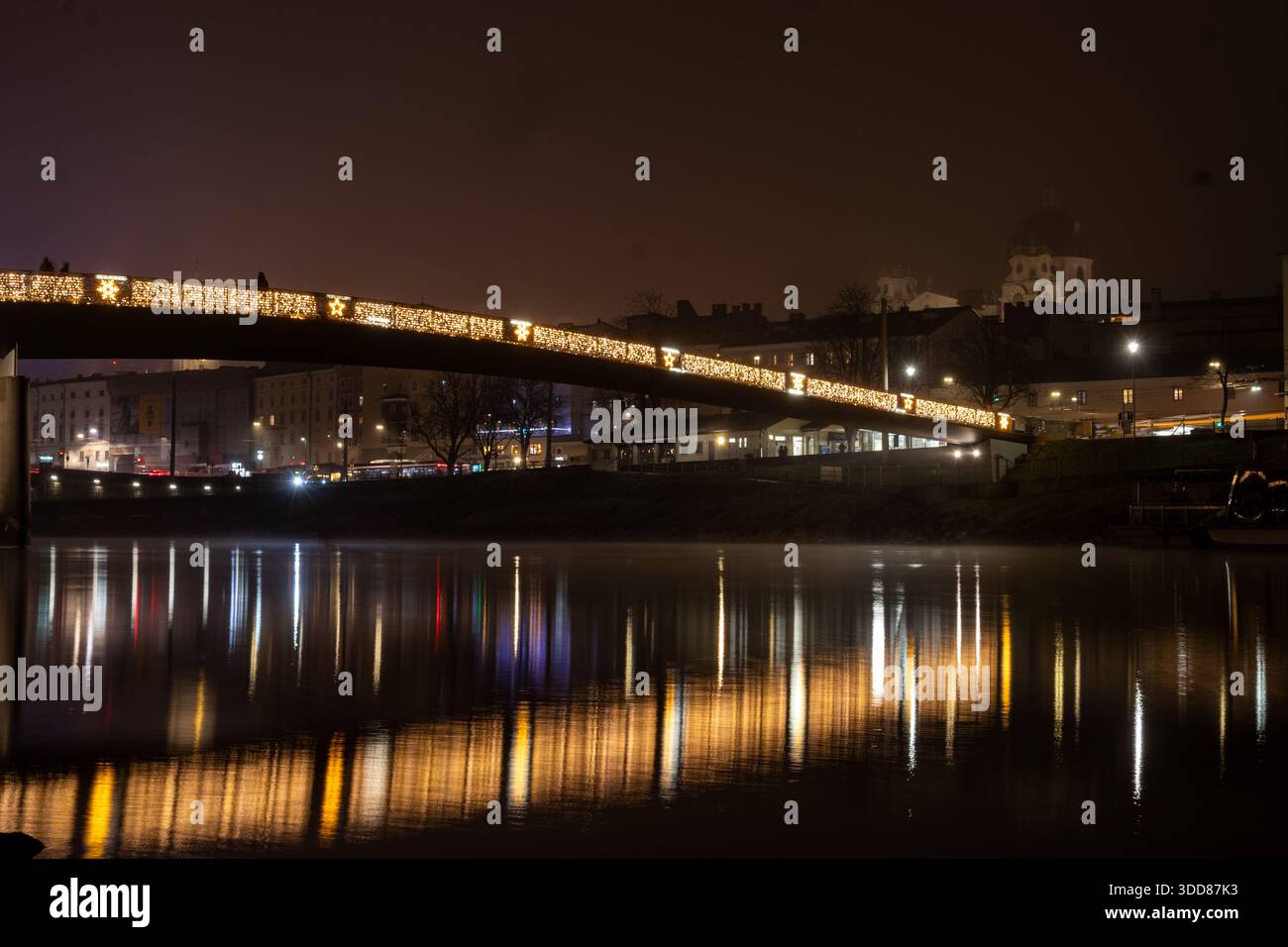 Une photographie longue exposition capture la beauté enchanteresse de Salzbourg, en Autriche, pendant la période de Noël. Un pont orné de Noël scintillant Banque D'Images
