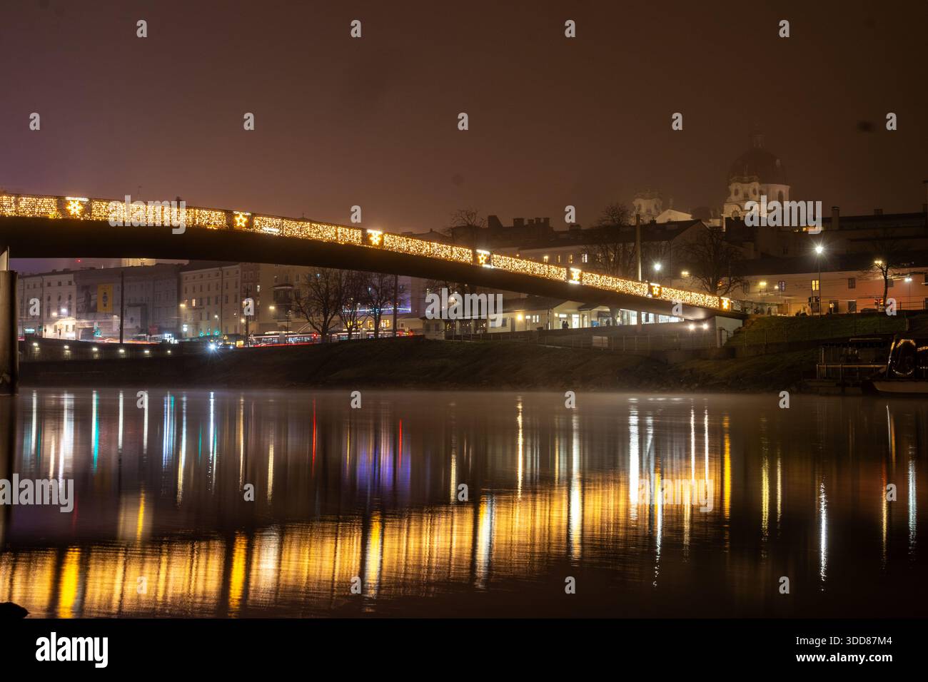 Une photographie longue exposition capture la beauté enchanteresse de Salzbourg, en Autriche, pendant la période de Noël. Un pont orné de Noël scintillant Banque D'Images