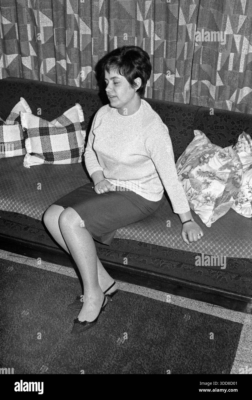 Sechzigerjahre, 10.04.1966, Deutschland, Menschen, Frauen, Frau 25 bis 28 Jahre in Pulli und Rock sitzt im Wohnzimmer auf einem Sofa mit Kissen, Hochfrisur, Doris Sechzigerjahre, 10.04.1966, Allemagne Menschen, Frauen, Frau 25 bis 28 Jahre in Pulli und Rock sitzt im Wohnzimmer auf einem Sofa mit Kissen, Hochfrisur, Doris, années 60, 10.04.1966, Allemagne, les gens, les femmes, femme 25 à 28 ans en pull et jupe se trouve dans le salon sur un canapé avec des oreillers, cheveux épinglés, Doris *** Sixties, 10 04 1966, Allemagne, les gens, les femmes, la femme 25 à 28 ans en pull et jupe se trouve dans le salon o Banque D'Images
