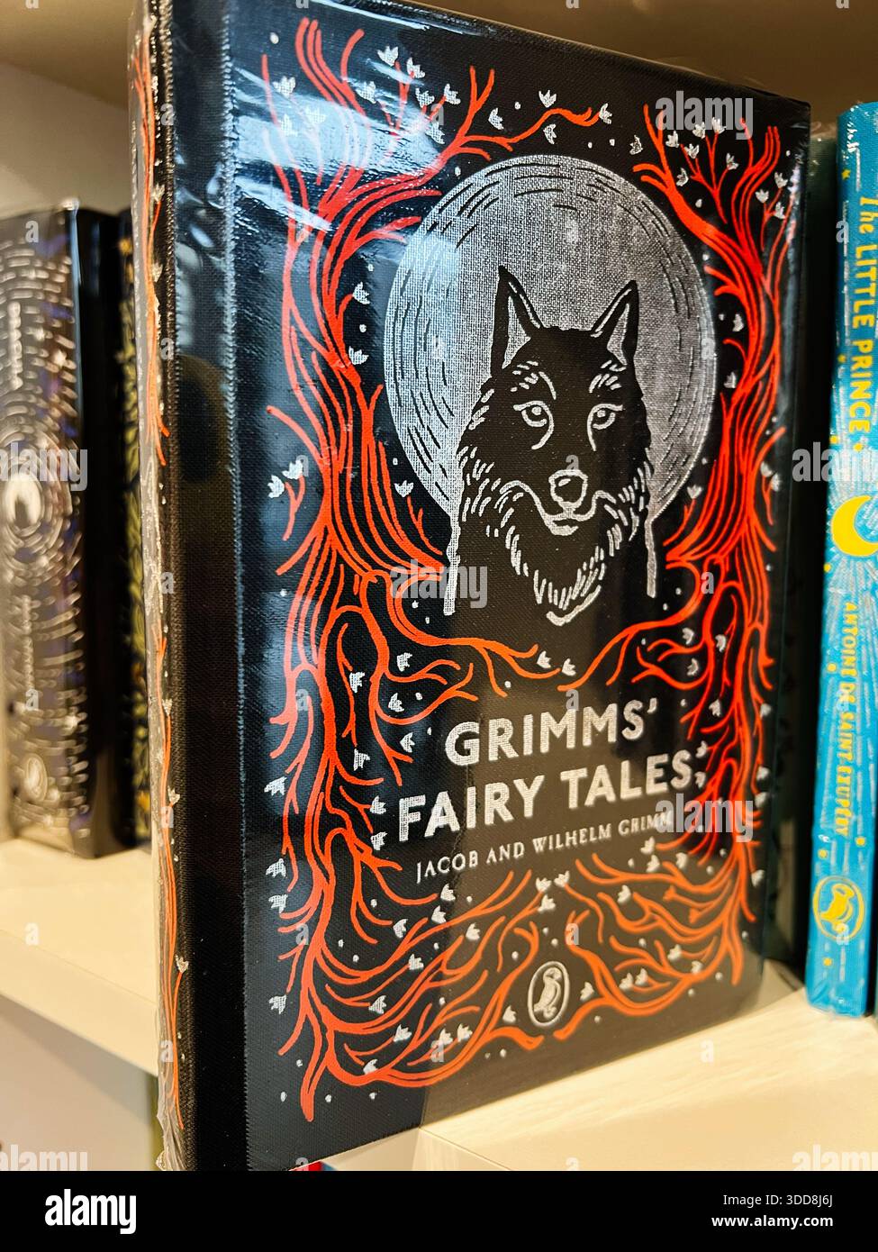 Londres, Royaume-Uni - 12 décembre 2025 : couverture de livre illustré vintage avec un loup, un encadrement rouge orné et une toile de fond de lune. Grimms' Fairy Tales Banque D'Images