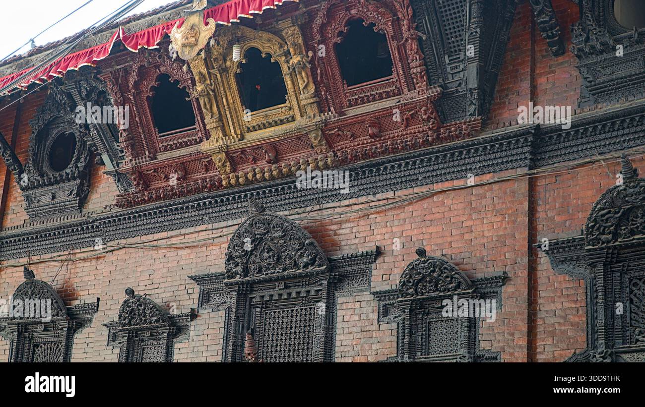 Bâtiment avec fenêtres traditionnelles et boiseries ornées à la maison Kumari. Banque D'Images