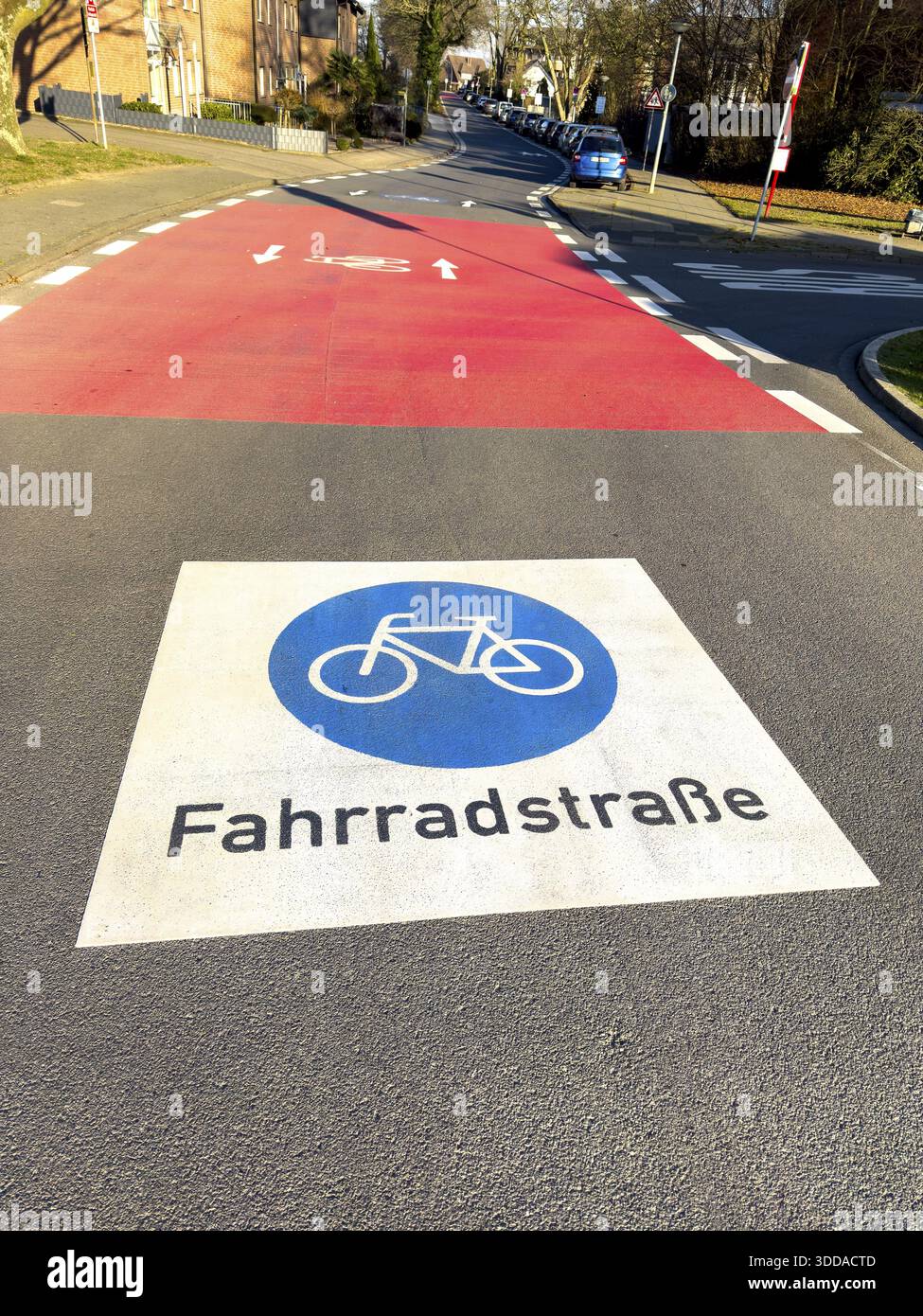 Grand marquage sur la route peint symbole pour les panneaux de signalisation routière 244.1-40 début fin d'une route cyclable, derrière elle rouge intersection route confluence, Allemagne Banque D'Images