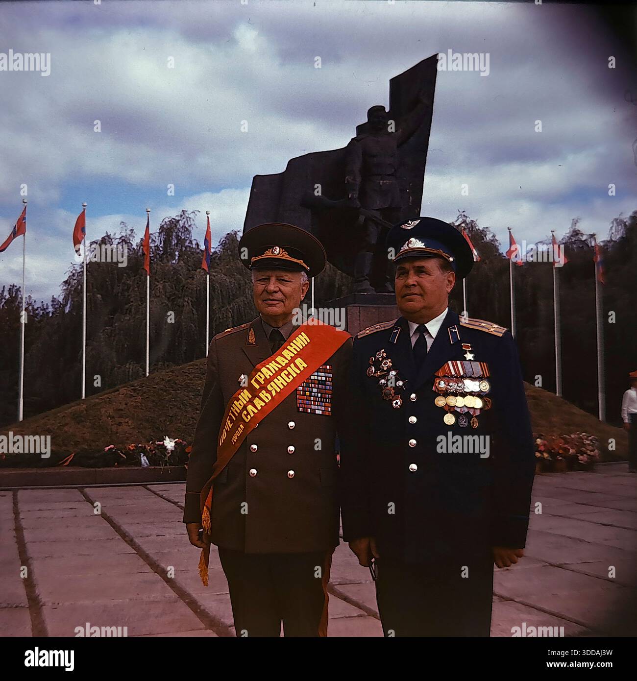 Slavyansk, Ukraine, URSS, années 1980 Portrait historique de deux héros de guerre soviétiques décorés dans le parc Lénine (aujourd'hui parc Shelkovichny). Sur la gauche se trouve le maréchal des troupes blindées Oleg Losik, portant une ceinture rouge « citoyen d'honneur de la ville de Slavyansk ». Sur la droite se trouve le héros de l'Union soviétique, le pilote de l'armée de l'air Vladimir Shandula. Ils posent en uniforme devant le monument de libération de la seconde Guerre mondiale. Cette image d'archives capture la commémoration des chefs militaires Banque D'Images