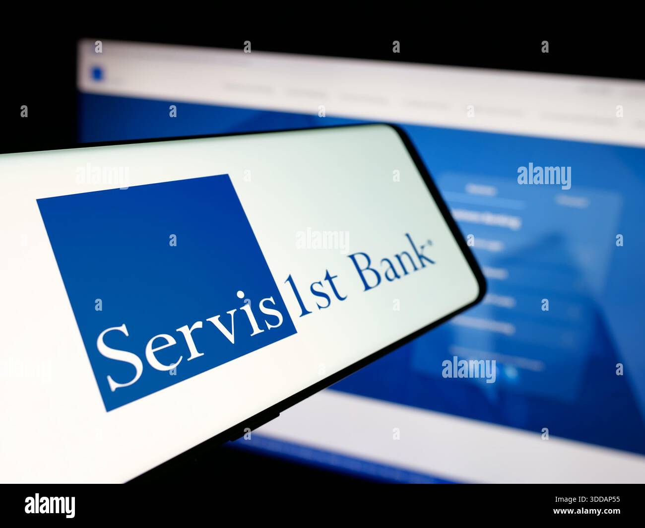 Stuttgart, Allemagne - 12-12-2025 : smartphone avec le logo de la banque américaine ServisFirst Bancshares Inc sur l'écran en face du site Banque D'Images