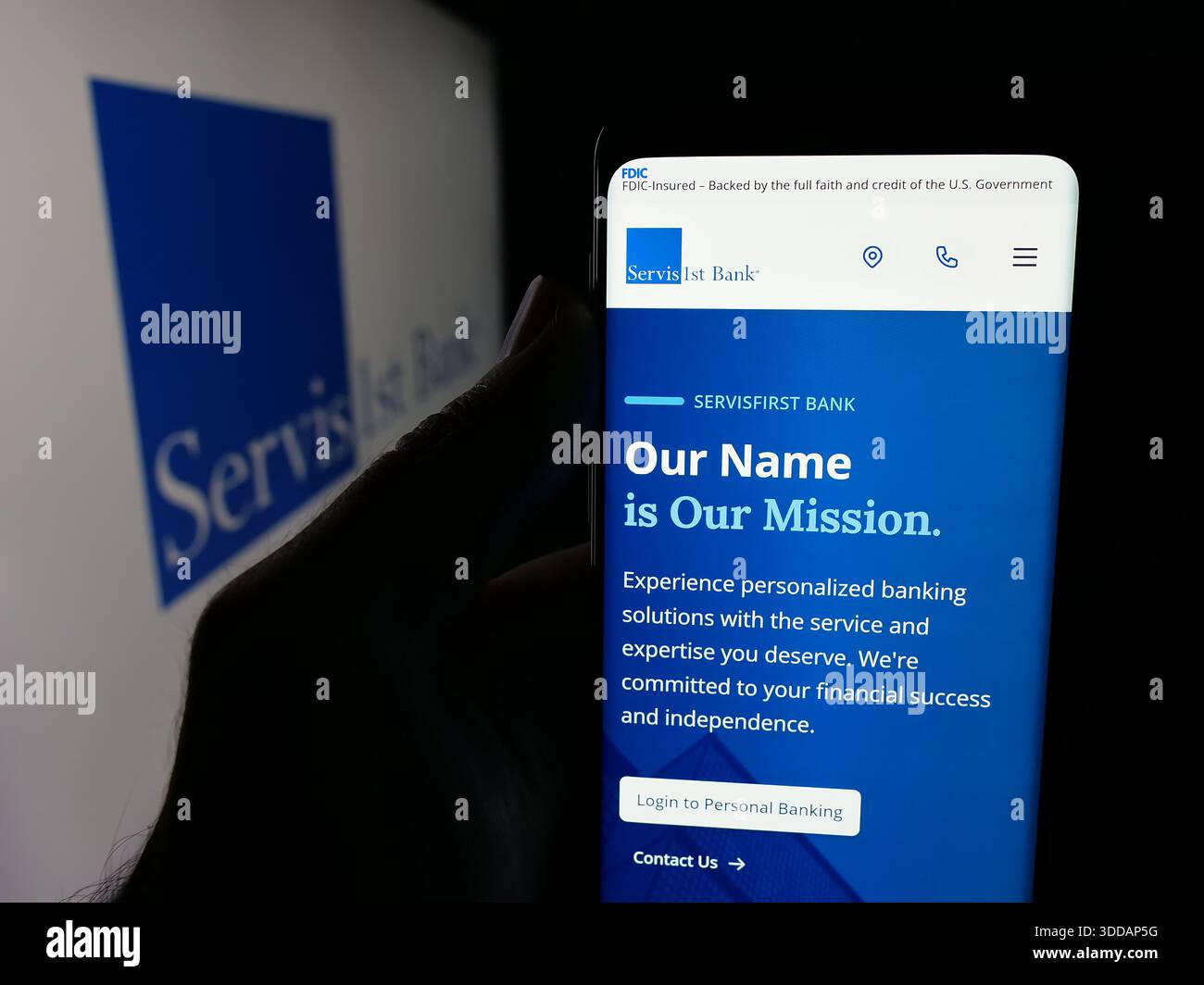 Stuttgart, Allemagne - 12-12-2025 : personne tenant un smartphone avec la page web de la banque américaine ServisFirst Bancshares Inc sur l'écran devant le logo. Banque D'Images