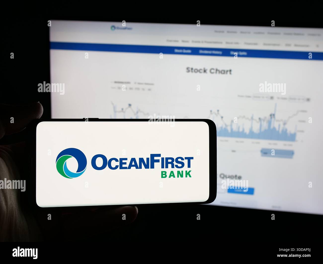 Stuttgart, Allemagne - 12-12-2013 2025 : personne tenant un smartphone avec le logo de la banque américaine OceanFirst Financial Corp. sur l'écran devant le site Web. Banque D'Images