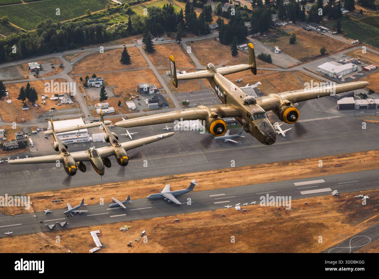 Un bombardier nord-américain B-25 Mitchell et un Lockheed P-38L Lightning volent ensemble en formation lors du salon aéronautique international d'Abbotsford au Canada en 2025. Le B-25, immatriculé N8195H et marqué Army Air Forces Serial 43-0748 avec le nez art 'Heavenly Body', est accompagné du P-38L Lightning immatriculé N2114L avec les numéros de code NX2114L, 427083 et 5781. Le P-38 présente des flèches jumelles distinctives et un accent visible de couleur mandarine, mettant en évidence deux avions restaurés de la seconde Guerre mondiale en vol coordonné. Banque D'Images