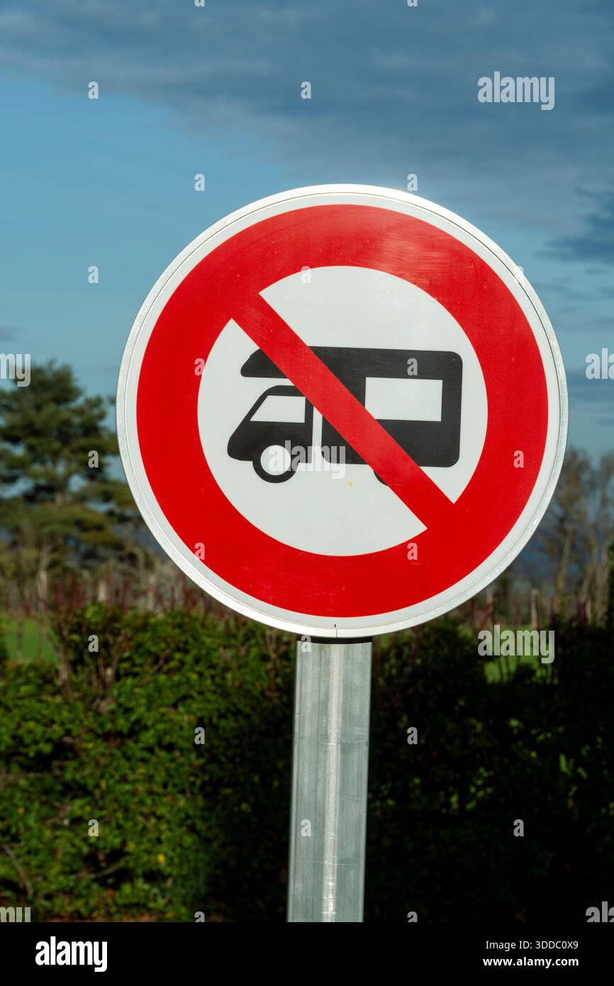 Un panneau routier rond interdit les camping-cars. Le panneau est blanc avec une bordure rouge et une diagonale rouge à travers le symbole du camping-car en France. Banque D'Images