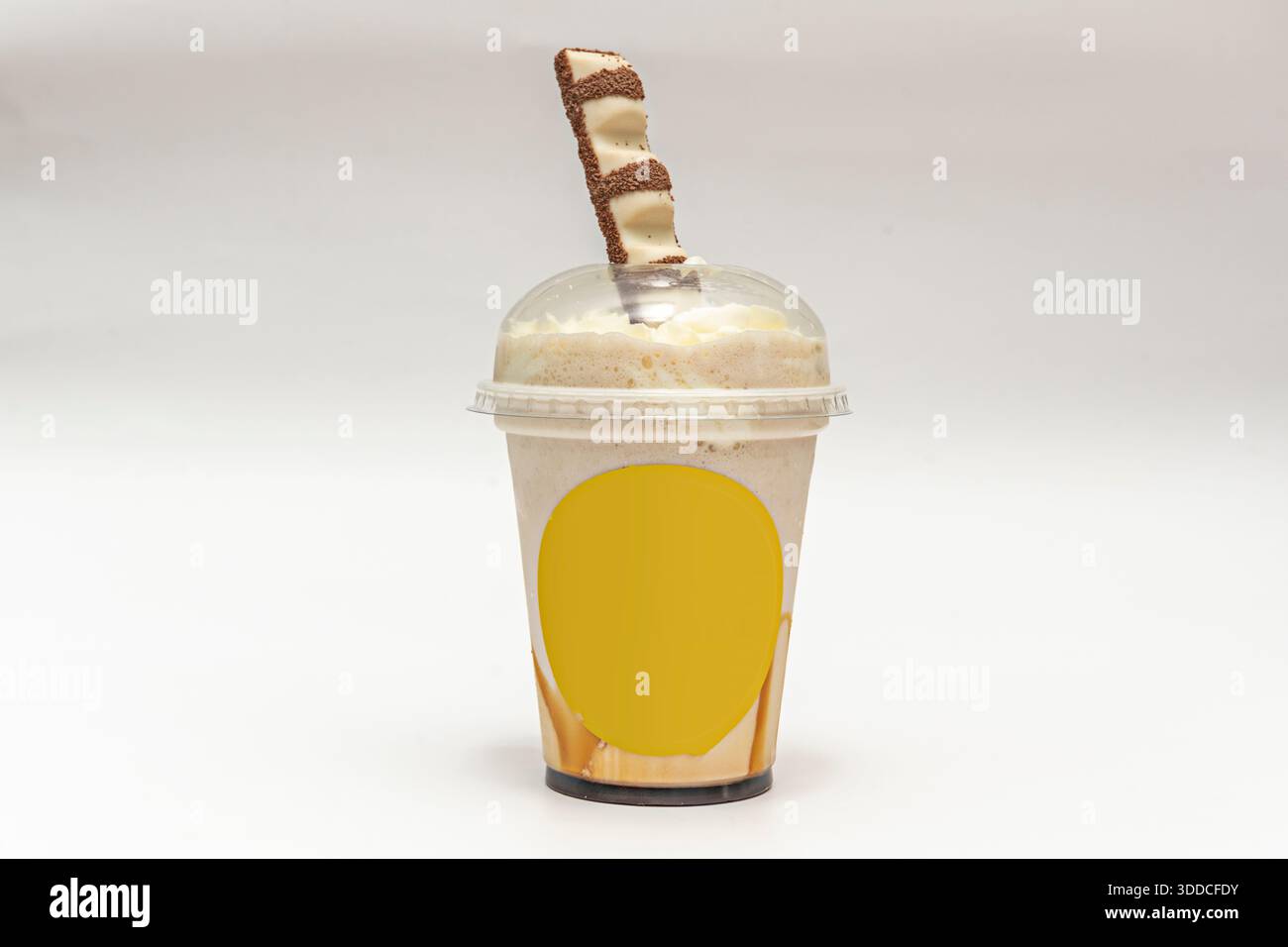 Un milkshake avec un biscuit pour les enfants dans un gobelet en plastique pour la livraison à domicile Banque D'Images