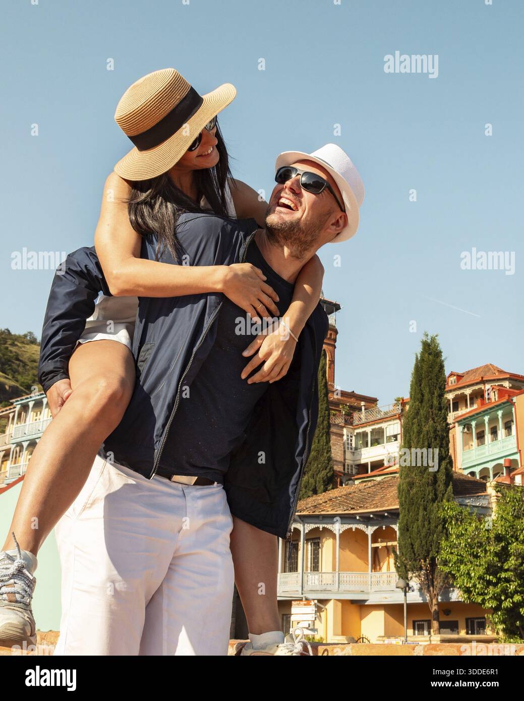 Couple romantique touristes ayant du plaisir à marcher dans les rues de la ville de Tbilissi en vacances. Heureux amis riant ensemble en vacances - les gens et le concept de vacances Banque D'Images
