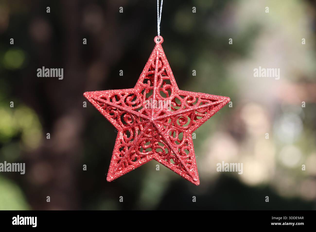 Décoration étoile rouge suspendue avec motif festif tourbillonnant. Ornement Christrmas. Banque D'Images
