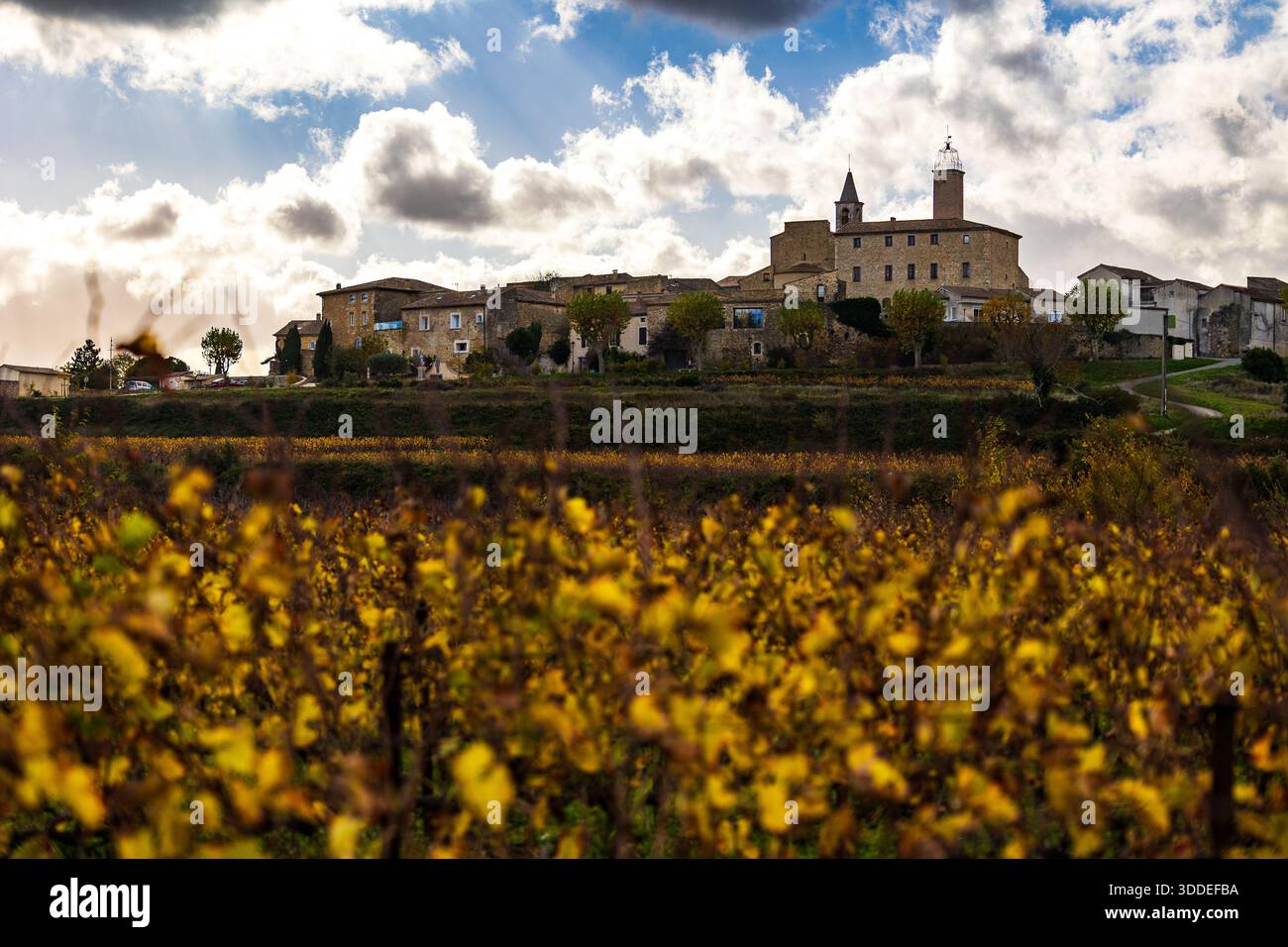 Village médiéval de Saint-Alexandre construit sur une colline vue des vignes en contrebas, teinté de couleurs automnales Banque D'Images