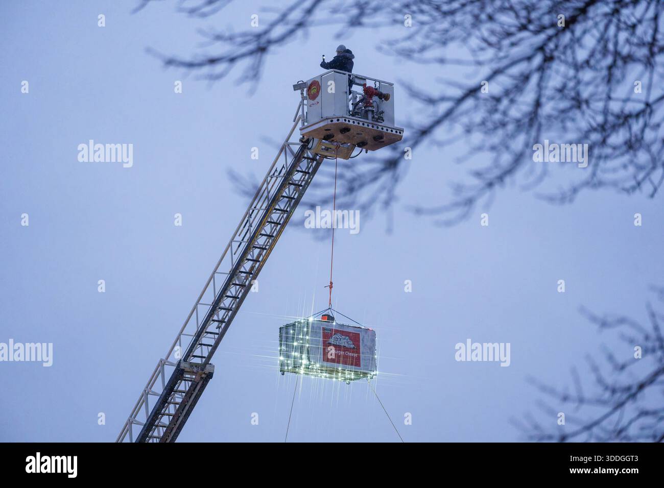 Monroe, États-Unis. 31 décembre 2025. À Monroe, Wisconsin, le 31 décembre 2025, une grande réplique de brique de fromage Limburger est descendue de l'échelle d'un camion de pompiers près du palais de justice historique. La ''Cheese Drop'' annuelle a lieu à 17h00 CST pour coïncider avec minuit en Suisse, honorant le profond héritage suisse et l'histoire de la fabrication du fromage de la ville. (Photo de Ross Harried/NurPhoto) crédit : NurPhoto SRL/Alamy Live News Banque D'Images
