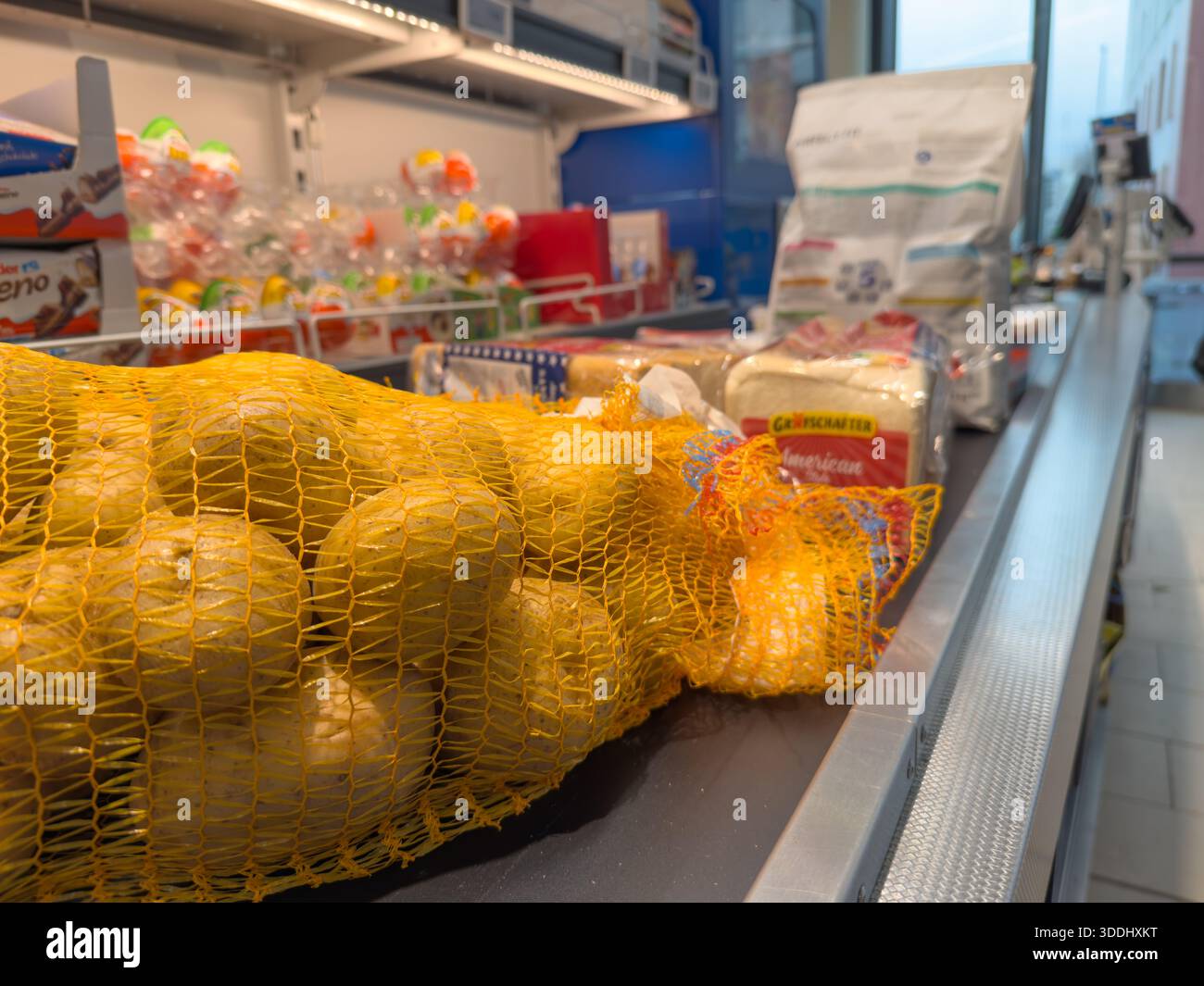 Allemagne Berlin 29 décembre 2025. Sac de pommes de terre fraîches sur un tapis roulant de caisse de supermarché. Les épiceries et les aliments emballés attendent le paiement dans un re Banque D'Images