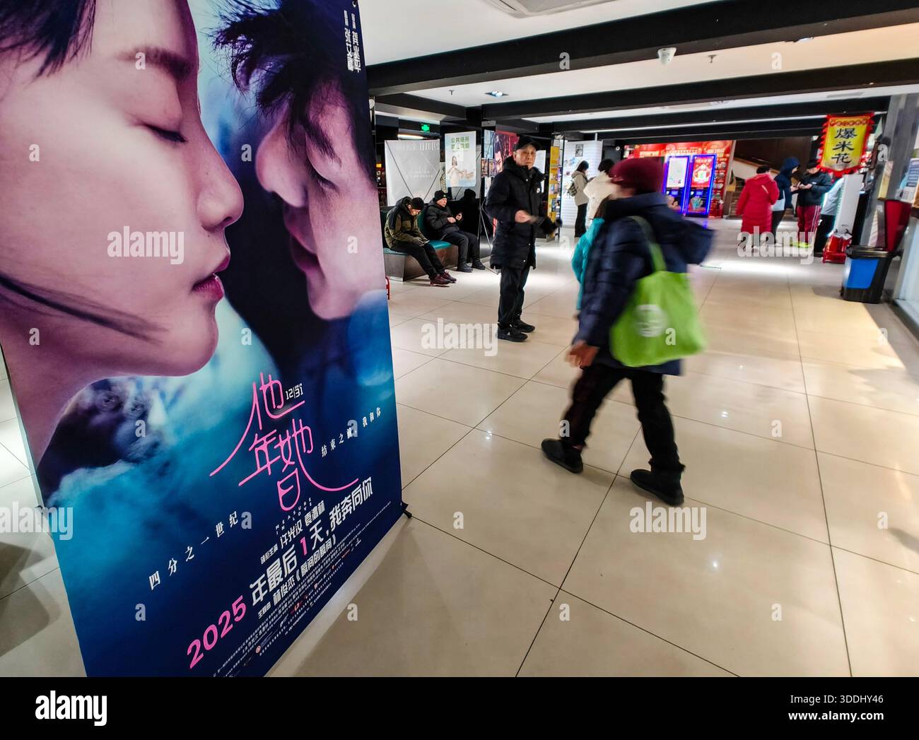 Pékin, Chine. 31 décembre 2025. Cette photo prise avec un téléphone portable montre un public marchant devant une affiche de film dans un cinéma à Pékin, capitale de la Chine, 31 décembre 2025. Le marché chinois du cinéma a connu un retour puissant en 2025, avec des ventes annuelles de billets en hausse de près de 22% à environ 51,83 milliards de yuans (environ 7,37 milliards de dollars américains), alimentées par un boom de l'animation sans précédent qui a vu le genre réclamer près de la moitié des revenus totaux, selon les données de China film Administration publiées jeudi. Crédit : Chen Yehua/Xinhua/Alamy Live News Banque D'Images