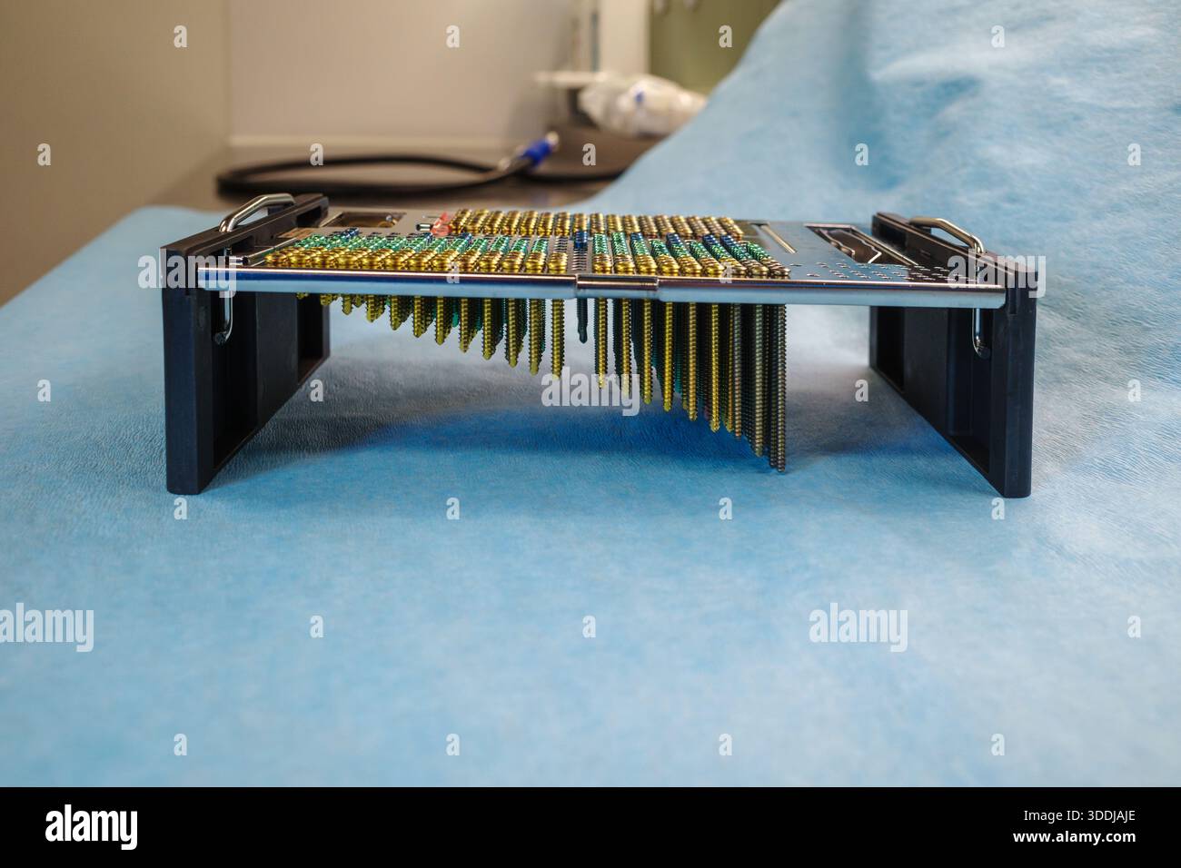 Photographie en studio haute résolution d'une vis chirurgicale et d'un plateau d'implant avec des vis médicales à code couleur disposées dans un organisateur métallique de précision sur un Banque D'Images