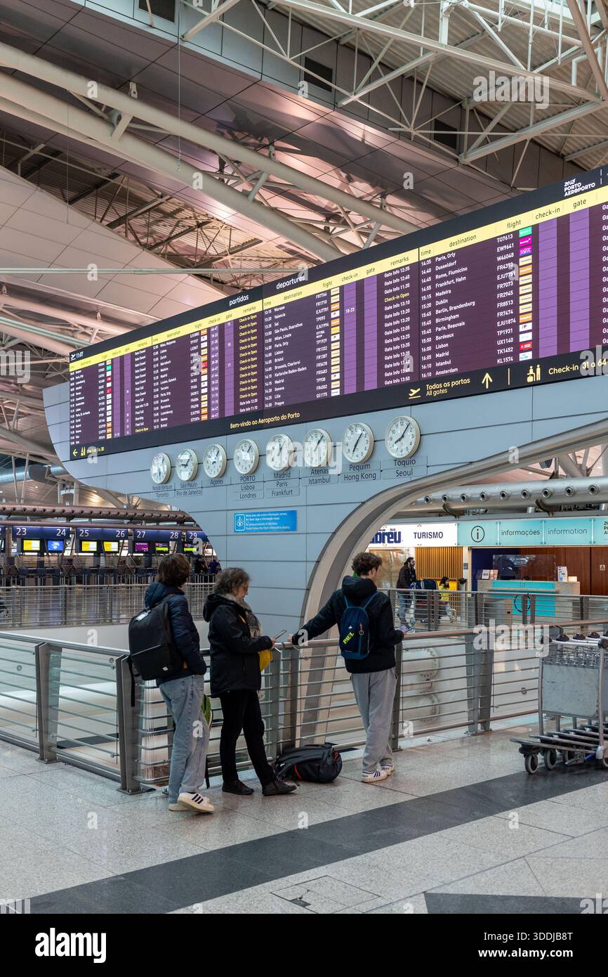 Un tableau numérique des départs indique les retards et les changements de porte d'embarquement pendant les perturbations nationales des voyages à l'aéroport de Porto. 01 janvier 2026 Banque D'Images