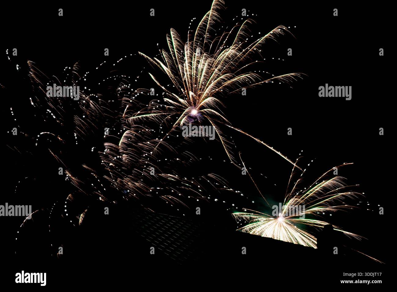 feux d'artifice aériens à pic élevé avec des flûtes scintillantes soufflant vers le bas, des étincelles multidirectionnelles et un noyau lumineux avec des particules traînantes, expansif Banque D'Images