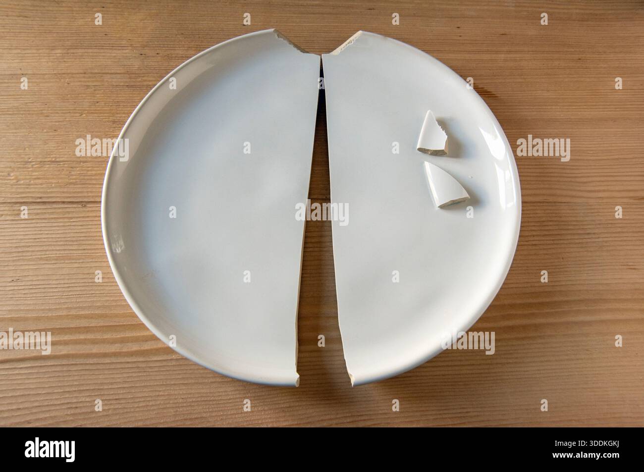 Plaque blanche cassée en deux parties, plaque désertique intelligente et moderne de la White Company, sur table de cuisine en bois Banque D'Images