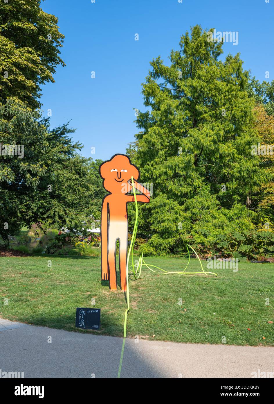 Nantes, France - 5 août 2025 : sculpture extérieure colorée d'une figure stylisée au jardin des plantes avec un corps orange et un visage souriant, stand Banque D'Images