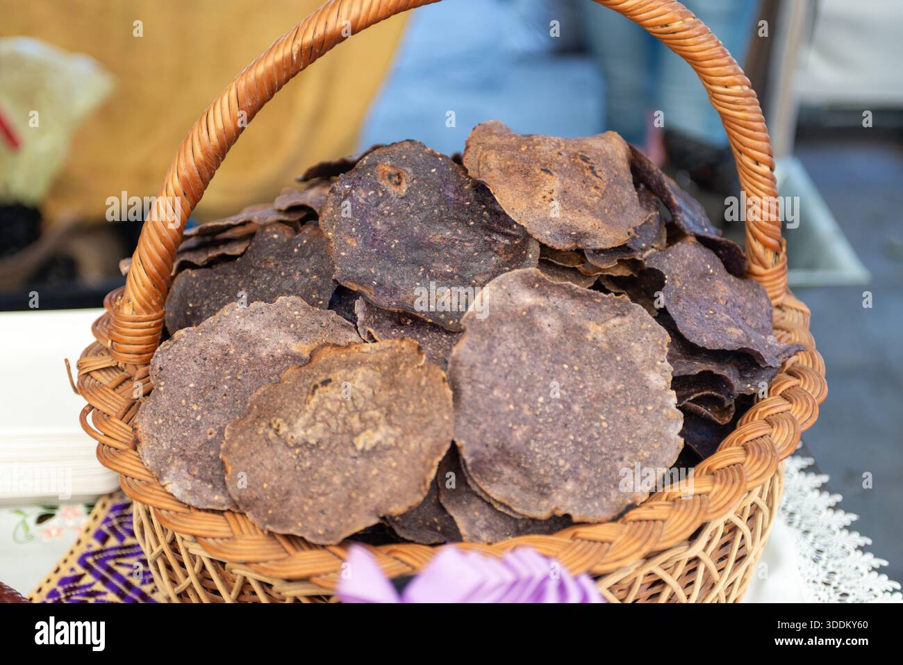 Panier tissé rustique rempli de croustilles de tortilla croustillantes au maïs violet Banque D'Images