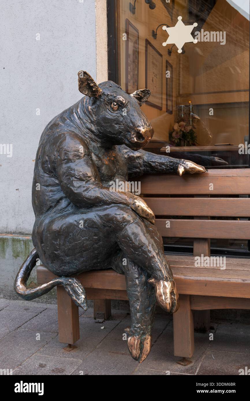 Black Angus Bull assis sur un banc en bois, sculpture en bronze devant le Goodwin Steak House à Tallinn, Estonie. Banque D'Images