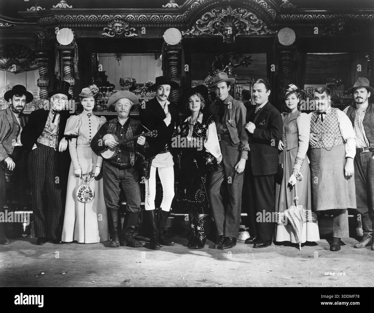 ALLEN JENKINS, SAMUEL S. HINDS, UNA MERKEL, CHARLES WINNINGER, MISCHA AUER, MARLENE DIETRICH, JAMES STEWART, BRIAN DONLEVY, Irene HERVEY, BILLY GILBERT et WARREN HYMER posant sur le tournage de DESTRY RIDES AGAIN 1939 réalisateur GEORGE MARSHALL Gowns VERA WEST Directeur de la photographie HAL MOHR producteur JOE PASTERNAK Universal Pictures Banque D'Images