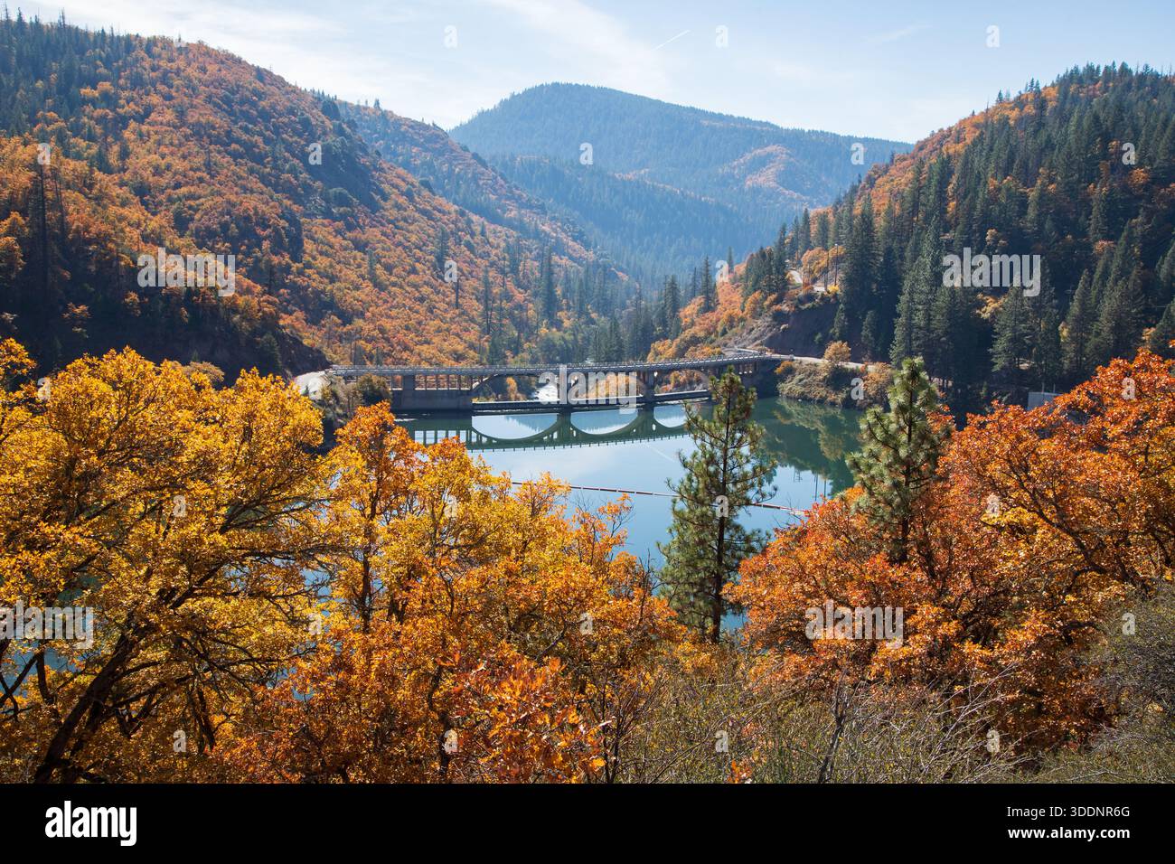 Vue d'automne élevée du barrage Pit 3 enjambant le lac Britton, entouré de feuillage d'automne coloré et de montagnes boisées dans le comté de Shasta, en Californie. Banque D'Images