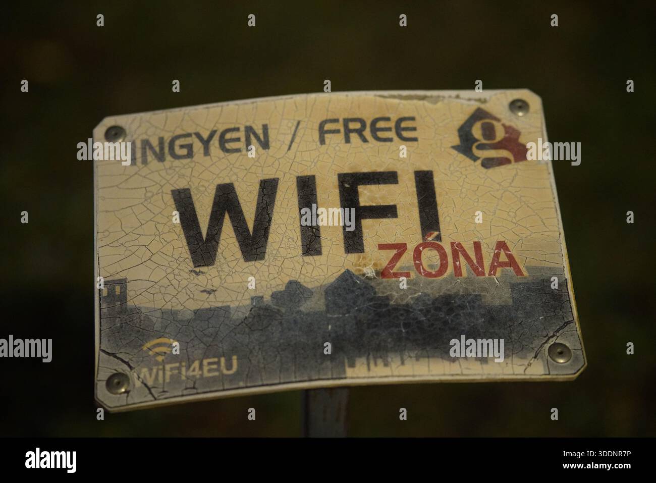 Signe altéré marquant une zone Wi-Fi publique gratuite, montrant de la peinture fissurée et des vêtements de plein air.Budapest, Hongrie Banque D'Images